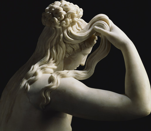 Detail of the Marine Venus: sideview of her head and hair. It is styled in a knot at he back of the head with long curls flowing down her shoulders, a strand of which she lifts to wring out the water.