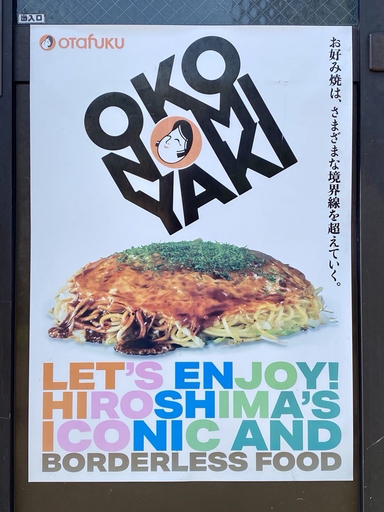 An advertisement featuring the Japanese dish Okonomiyaki with text "Let's Enjoy Hiroshima's Iconic and Borderless Food." There's Japanese text on the right side and the "Otafuku" logo at the top left.