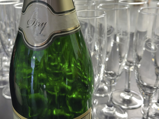 Eine Flasche Sekt vor Sektgläsern