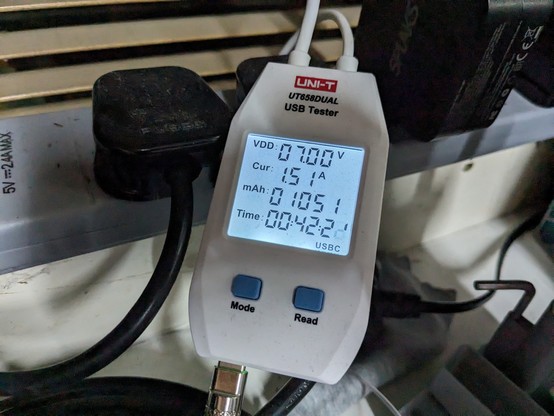 A USB C voltmeter displaying 7 volts and 1.51 amps charging 