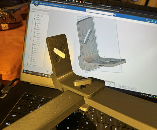 A plastic part in reality, the SolidWorks model behind it on my laptop screen. 