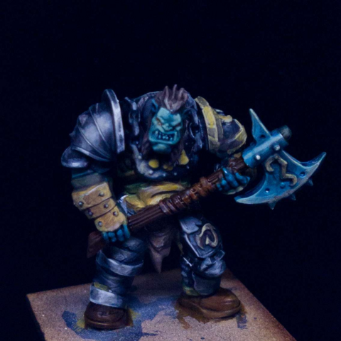 Badly painted ogre in steel armour holding an enormous fricken axe.