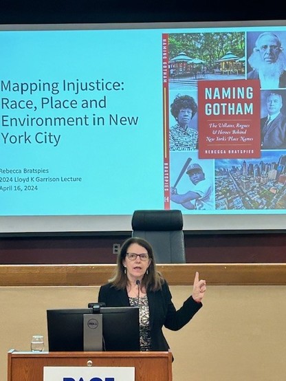another of me (a white woman with brown hair and glasses, wearing a black jacket) talking.  This time showing the book cover for Naming Gotham