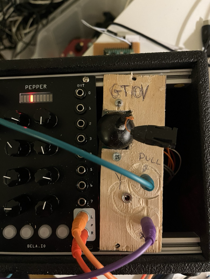 A picture of an ad hoc stnth module made of plywood with hand written labels