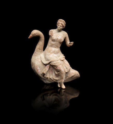 Figurine of Aphrodite sitting on a goose. The himation wrapped around her hips has slipped down, revealing her mons veneris. She is missing her right arm and left hand.