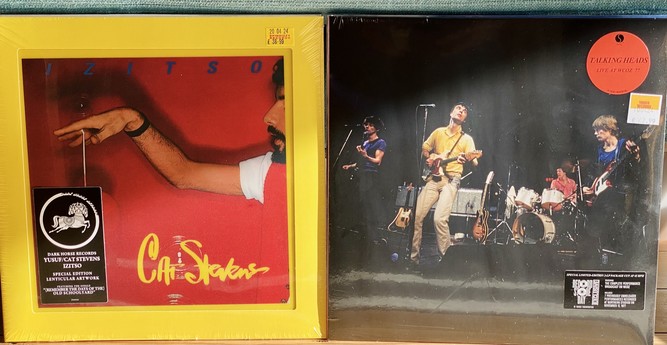 Two vinyl album covers on display; the left album features a stylized image of Cat Stevens with text "Izitso," the right album shows the band Talking Heads performing live, titled "Live at WCOZ '77."