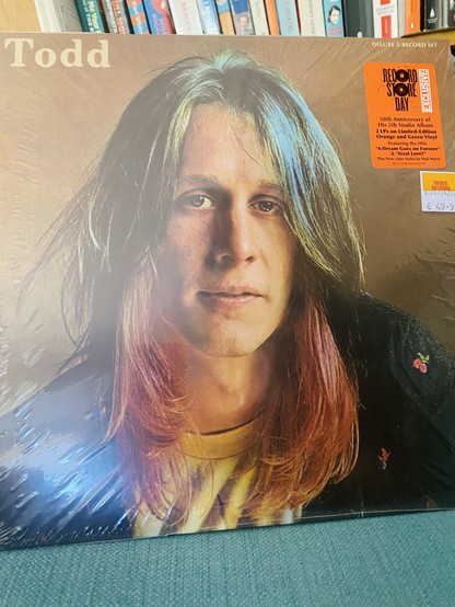 Vinyl record cover titled "Todd" featuring a portrait of a long-haired person. There's a sticker indicating it's a 50th-anniversary deluxe set for Record Store Day, with additional pricing and feature information.