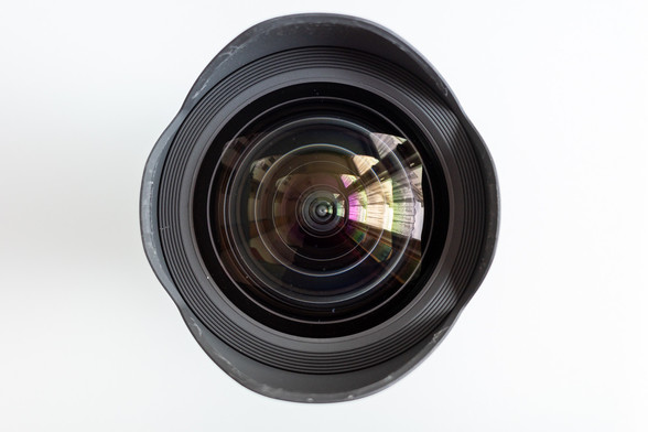 Foto: Objektiv von vorn, senkrecht von oben fotografiert, mit Spiegelungen in der Frontlinse