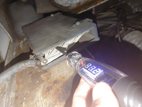 Test light probing a wiring harness of an ECU on a 1970 VW Squareback. It reads 11.2v, and the "positive" light is on.