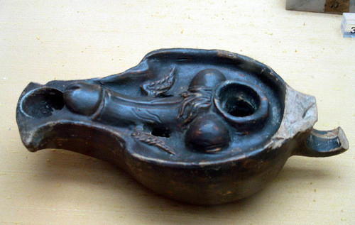 Oil lamp with a winged phallus relief that ends at the mouth of the lamp, creating the image of a phallus ejaculating fire while the lamp is lit.