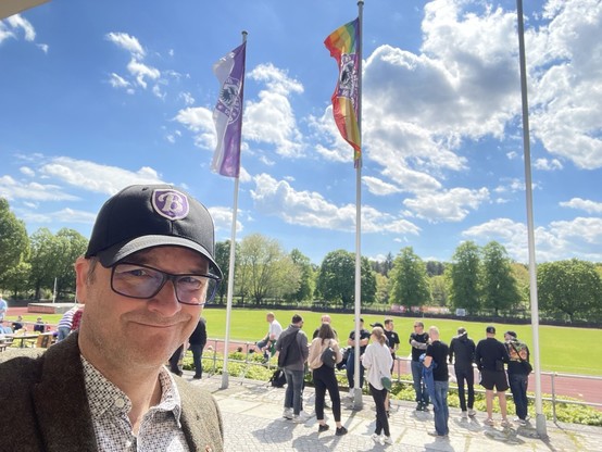 Mann mit Kappe im Fußballstadion. Fahnen von Tennis Borussia Berlin. 