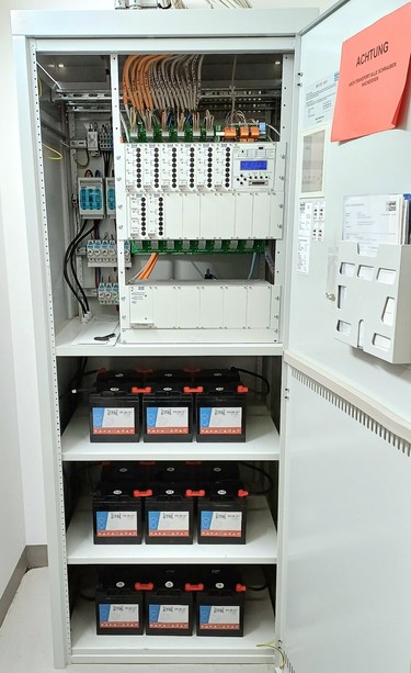 Safety lighting system cabinet with batteries
