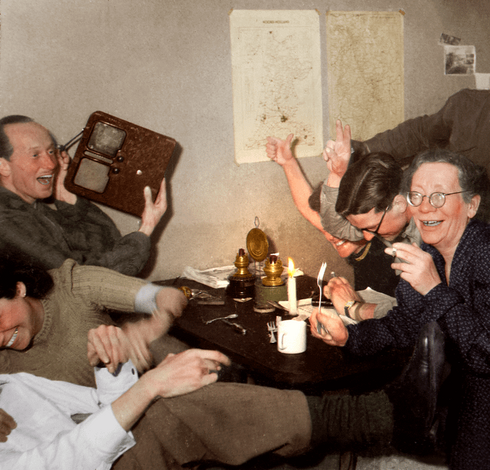Foto der feiernden Résistance mit dem Radio. Es wird geraucht, geküsst und jubiliert.