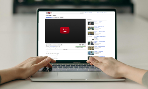 A photo of a person using a laptop, which features a classic YouTube interface on the screen. The featured video is "Yu-Gi-Oh! Abridged" episode 1, which has been hit by a copyright strike