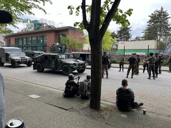 Movie set soldiers waiting for a shot on a street in Vancouver. With a Humvee with a heavy gun on it