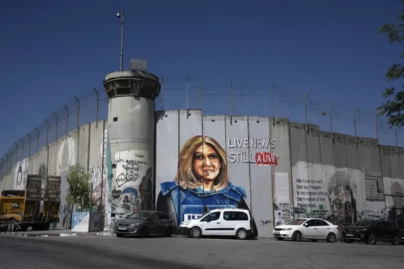 A mural depicting Al Jazeera’s slain Palestinian-American journalist Shireen Abu Akleh adorns a part of Israel’s controversial separation barrier, in the occupied West Bank city of Bethlehem in July 2022. The mural was painted by Palestinian artist Taqi Spateen [Mahmoud Illean/AP Photo]