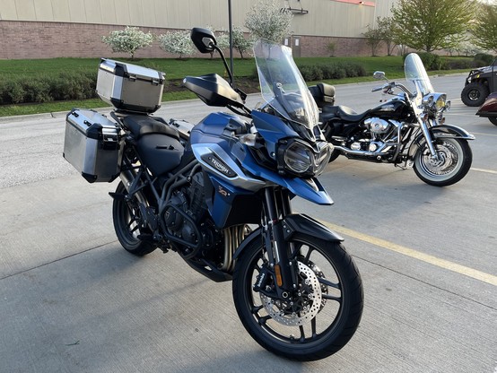 A blue 2018 Triumph Tiger 1200 XRx motorcycle, equipped with aluminum luggage.