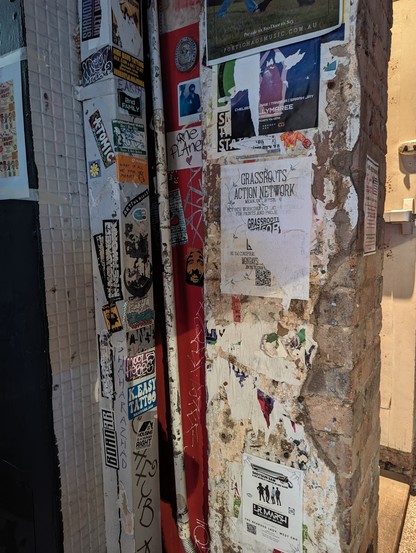 Doorway with flyposters and old papers stuck to the grating cement