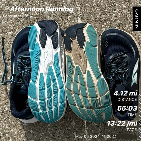 Two pairs of running shoes, (Altra Paradigm) new pair on the left old pair on the right. The right foot of the left pair and the left foot of the right pair have soles facing up. Overlaid on the image of sneakers,  statistics of an afternoon run featuring distance (4.12 miles), time (55 min 3 sec), and pace (13 min 22 sec per mile), with a timestamp indicating May 05, 2024.