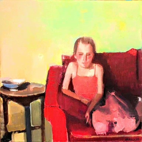 Young woman dressed in red sitting curled up on red couch 