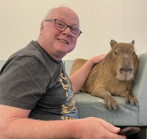 Picture of myself with Pisuke, a friendly capybara, at Cafe Capyba, Tokyo.
