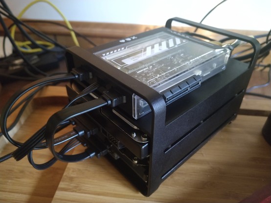 A "zimablade" - a black plastic box with Walkman vibes, a clear panel revealing a single board computer inside. This is wired up to two 3.5" hard drives, and the whole assembly stacked together on a tidy but revealing black folded sheet metal frame.