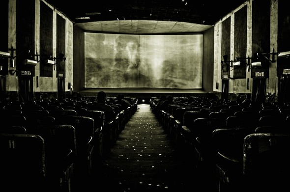 old black and white photo of the interior of a cinema while a film is being projected