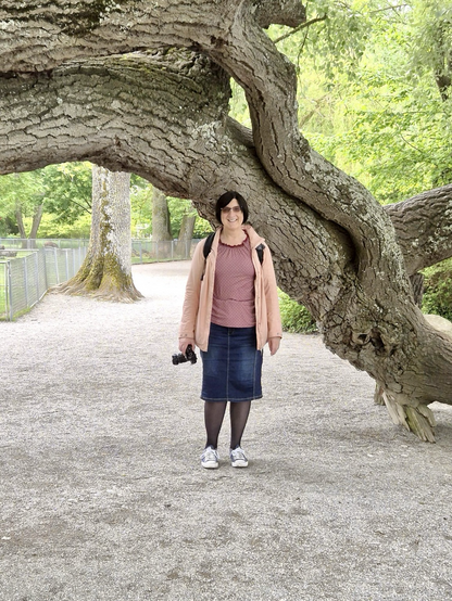 Michaela steht vor einem Baum
