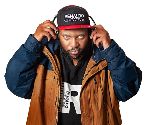 A man standing holding headphones with an intense look on his face. 