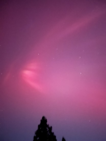 Pink horizontal “shock wave” aurora fairly high above the horizon.