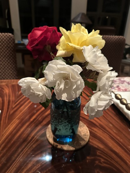 White yellow and red roses in a blue vase