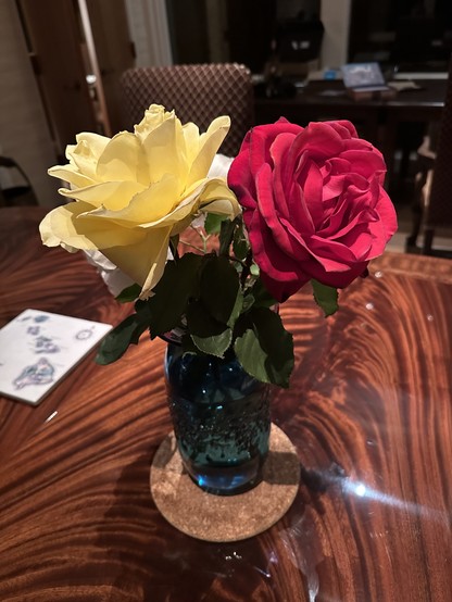 Yellow and red roses in a blue vase.