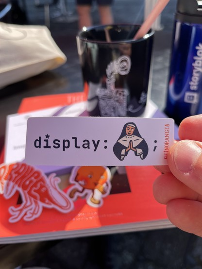 A sticker show the CSS display property with an actual “nun” icon as value with praying hands. 