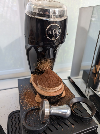 Coffee grinder that has spilled coffee grinds all over the table because I forgot to put the cup underneath