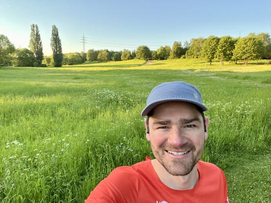 Selfie with a vibrant green field of the Südpark in the background. 