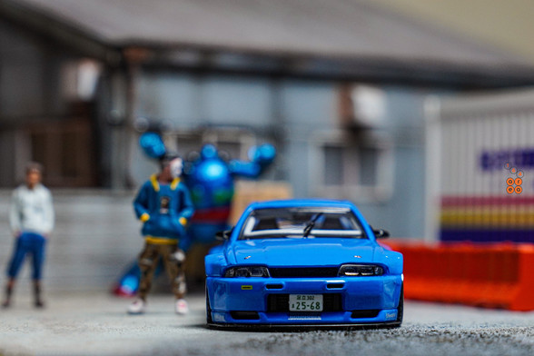 A front side of Nissan Skyline GT-R (R33), Rocket Bunny, Blue by INNO64 in 1:64 scale with 1:64 figure on AREA 164