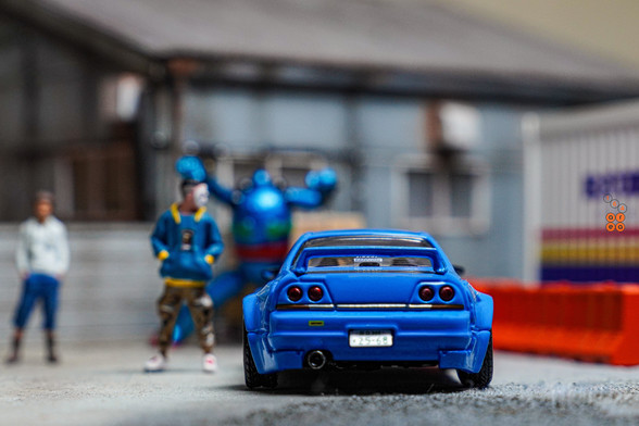 A rear side of Nissan Skyline GT-R (R33), Rocket Bunny, Blue by INNO64 in 1:64 scale with 1:64 figure on AREA 164