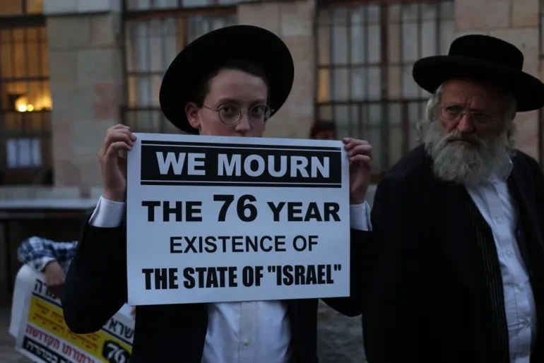 An Israeli ultra-orthodox Jew – many members of which are anti-Zionist – holds a banner during an anti-Independence Day protest at their Meah Shearim neighbourhood in occupied Jerusalem on May 14, 2024. Israel cancelled its official 76th Independence Day celebrations amid its war on Gaza [Atef Safadi/EPA]