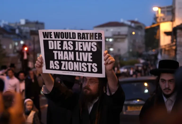 An ultra-orthodox Jew holds a banner against Zionism in protest against Israel’s national day on May 14 [Atef Safadi/EPA]