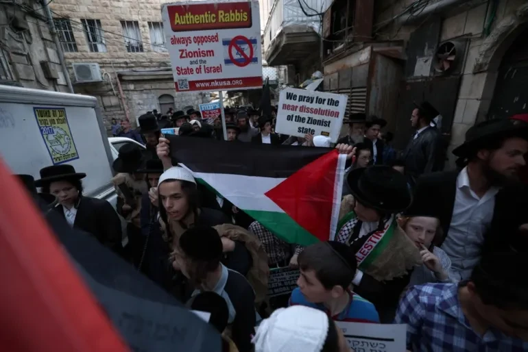 A Palestinian flag carried by ultra-orthodox Jews during their anti-Zionist protest [Atef Safadi/EPA]