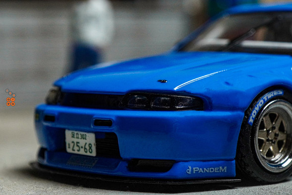 A close-up shot of Nissan Skyline GT-R (R33), Rocket Bunny, Blue by INNO64 in 1:64 scale with 1:64 figure on AREA 164