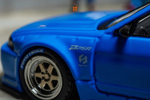 A close-up shot of Nissan Skyline GT-R (R33), Rocket Bunny, Blue by INNO64 in 1:64 scale with 1:64 figure on AREA 164