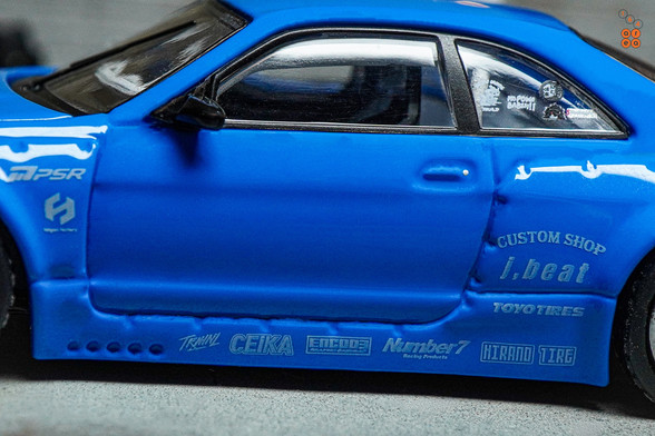 A close-up shot of Nissan Skyline GT-R (R33), Rocket Bunny, Blue by INNO64 in 1:64 scale with 1:64 figure on AREA 164