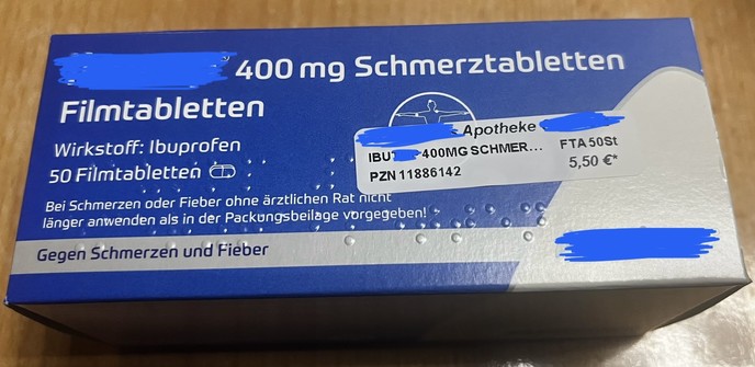 Foto einer Schachtel Ibuprofen 400 mg. Der Fokus liegt hierbei auf der Braille-Beschriftung, die teilweise (ausgerechnet die Dosierung) von einem von der Apotheke aufgeklebten Etikett mit PZN und Preis verdeckt wird.