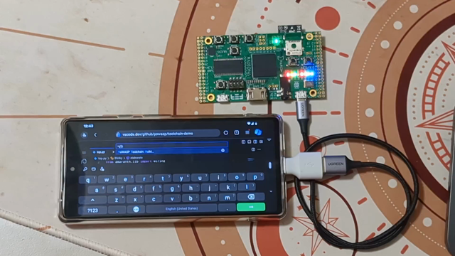 a video with a cellphone and an FPGA developer board. the phone shows the VS Code UI squished in a weird way. in the terminal, a lot of text from the FPGA toolchain scrolls by, until eventually the progress bar from the FPGA programmer finishes and the board starts blinking a LED

the URL in the browser is https://vscode.dev/github/yowasp/toolchain.demo
