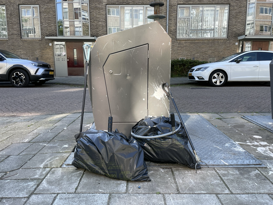 Trashbags in front of a trash container 