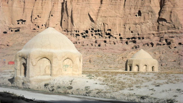 Mongol heritage. Two concrete yurts seen against a background of the cliffs that held the Buddhas.