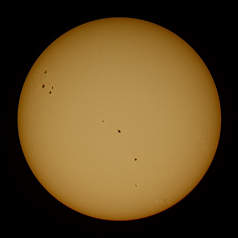 The yellow Sun with sunspots on a dark background. 