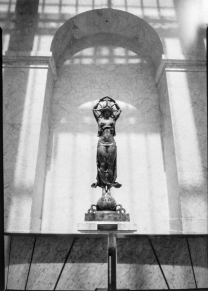 A black and white pinhole photo of a statue of a women wearing a star headdress 