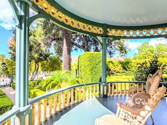 Painting of a beautiful rounded porch with pretty chairs